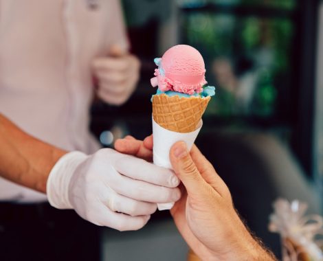 Summertime. Close-up view of man buying cone of ice-cream in kiosk, outdoors.